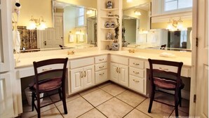 A corner bathroom with two sinks, white cabinets, and a large mirror. - Eufaula House (Eufaula)