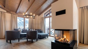 Een moderne woonkamer met een open haard, houten vloeren en een zithoek.