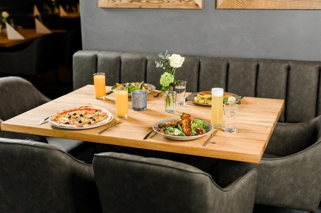 Ein Tisch mit Pizza, Salat und Getränken.