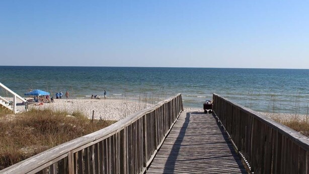A wooden boardwalk leading to a beach with a clear view of the ocean. - Brower's Lagoon Run at the Beach (Gulf Shores)