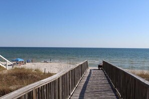 A wooden boardwalk leading to a beach with a clear view of the ocean. - Brower's Lagoon Run at the Beach (Gulf Shores)