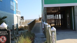 A pathway leading to a green building with a wooden fence and bollards. A sign indicates private property with a no entry symbol. - Brower's Lagoon Run at the Beach (Gulf Shores)