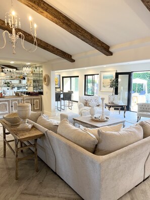 Relax in this stylish living area with a plush sofa, wooden coffee table, and elegant chandelier.