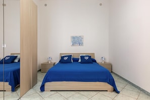 Un dormitorio con una cama, dos mesitas de noche, un espejo y una obra de arte colgada en la pared.