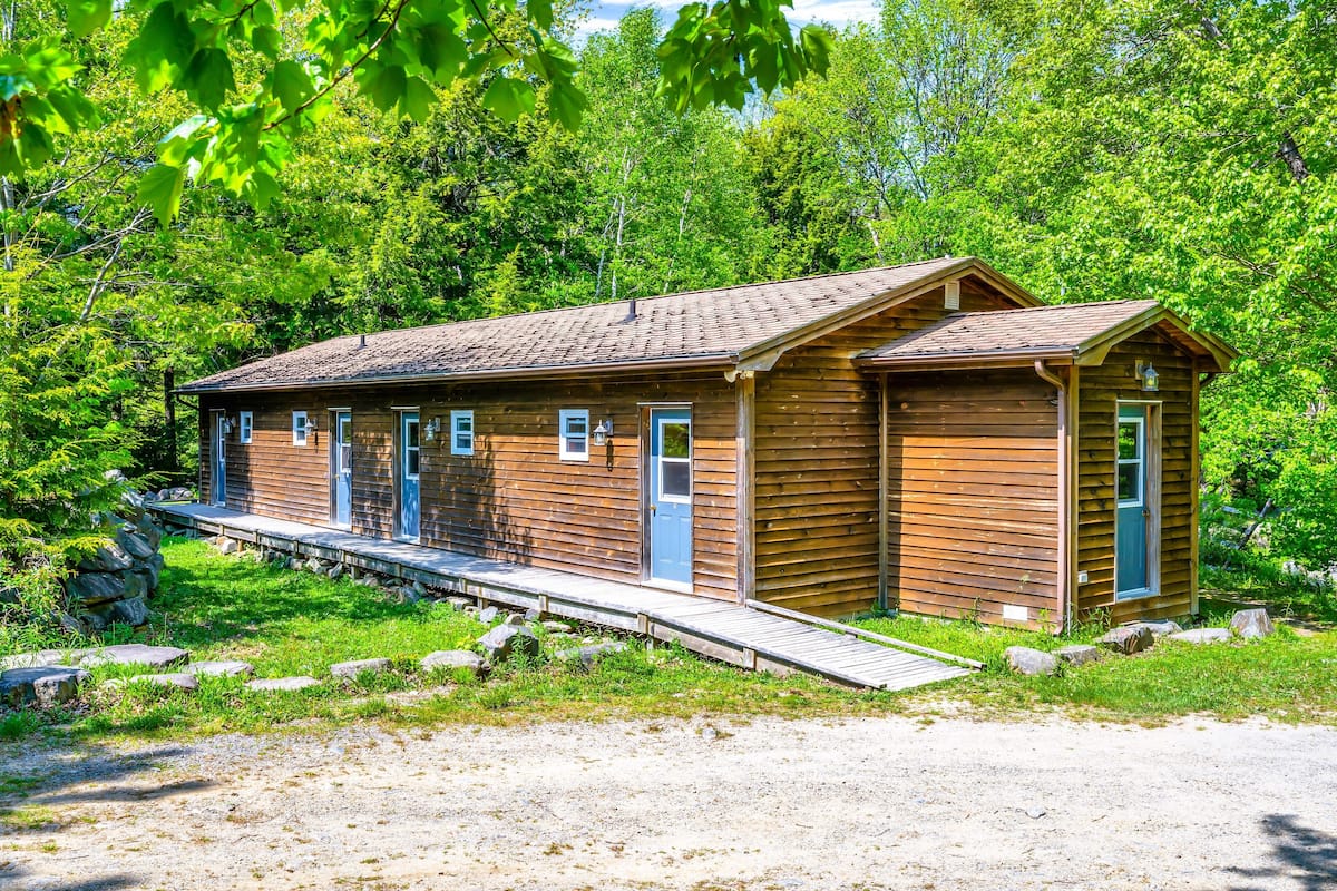 Eine Holzhütte mit einer kleinen Veranda und einer Rampe zum Eingang.