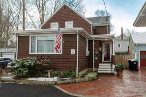 A two-story house with a front porch, a flag, and a brick driveway. - Lovely two bedrooms in the great historic town (Salem)