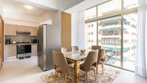 Une cuisine moderne avec un coin repas, de grandes fenêtres et une vue sur la ville.