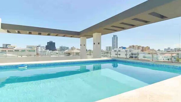 Une piscine sur le toit offrant une vue dégagée sur les gratte-ciel de la ville.