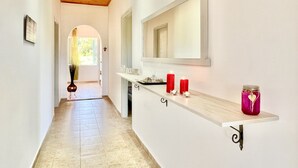 A hallway with a wooden ceiling, a mirror, and a shelf with candles. - Astra Beach House in Astrakeri Bay (Astrakeri)