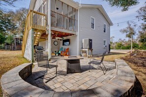 A house with a deck, outdoor seating, and a fire pit.