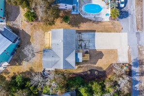 An aerial view of a residential property with a swimming pool, a garage, and a detached garage.
