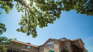 A hotel with a stone facade, multiple windows, and a green awning. - Ozark Retreat~Walk-In~Pointe Royale Resort~Pools/Hottub (Branson)