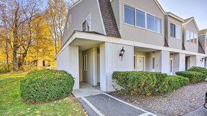 A two-story residential building with a covered front porch, a driveway, and well-maintained landscaping. - First-Floor Hunter Condo < 1 Mi to Slopes! (Hunter)