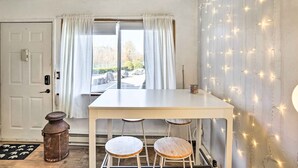 A room with a white table and two wooden stools, a white door, and a window with white curtains. - First-Floor Hunter Condo < 1 Mi to Slopes! (Hunter)