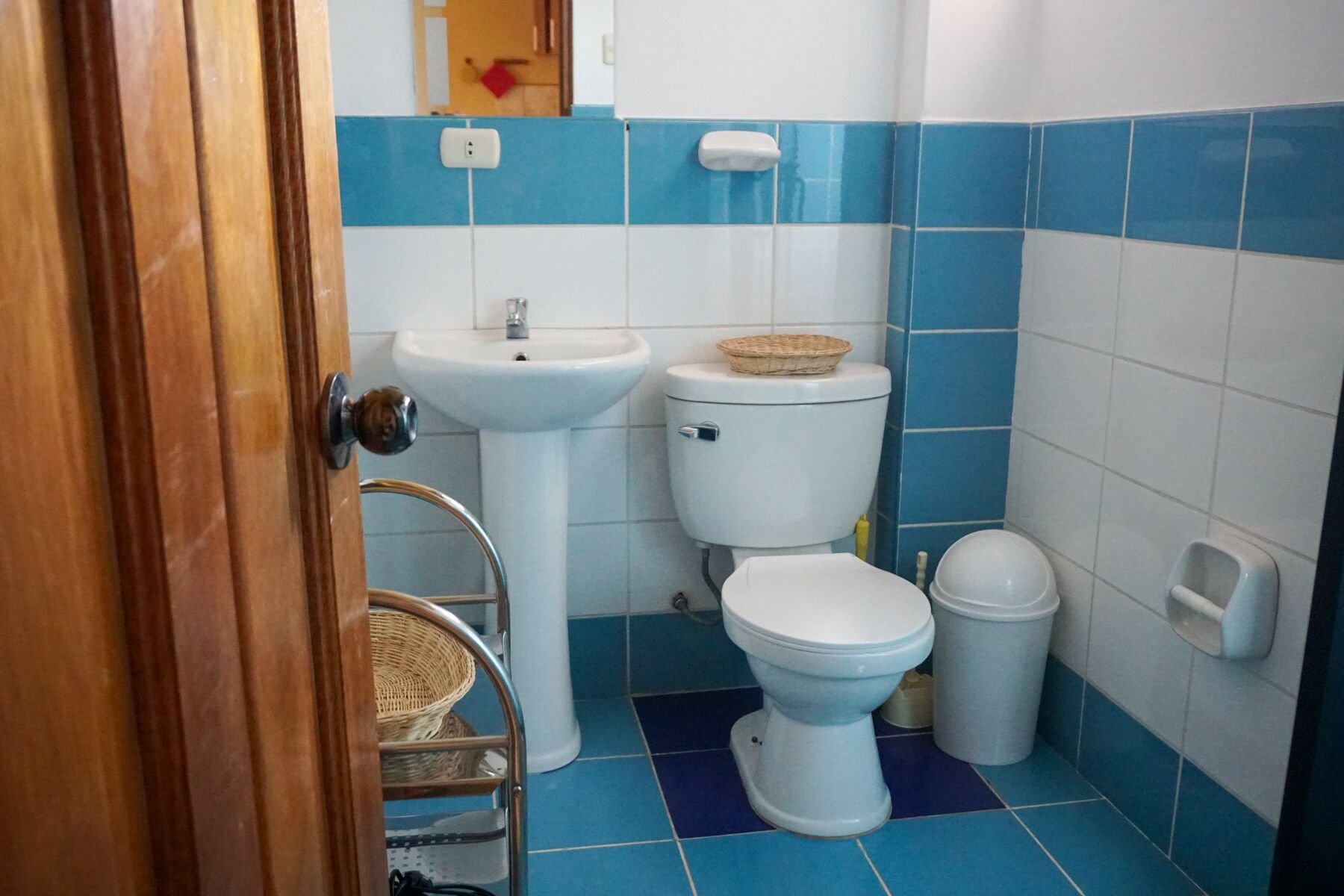 Ein Badezimmer mit Waschbecken, Toilette und Mülleimer.