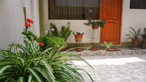 Un patio con macetas y una puerta de madera.