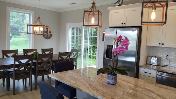 A modern kitchen with a marble island, stainless steel appliances, and pendant lighting. - Summer Oasis in Narragansett! 5BR Home Perfect for Family & Friends! (Narragansett)