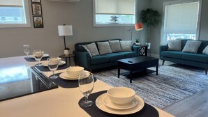 Un salon moderne avec un coin repas, comprenant un ensemble de canapés, une table basse et une table à manger pour les repas.