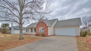 A two-story house with a brick section and a garage.