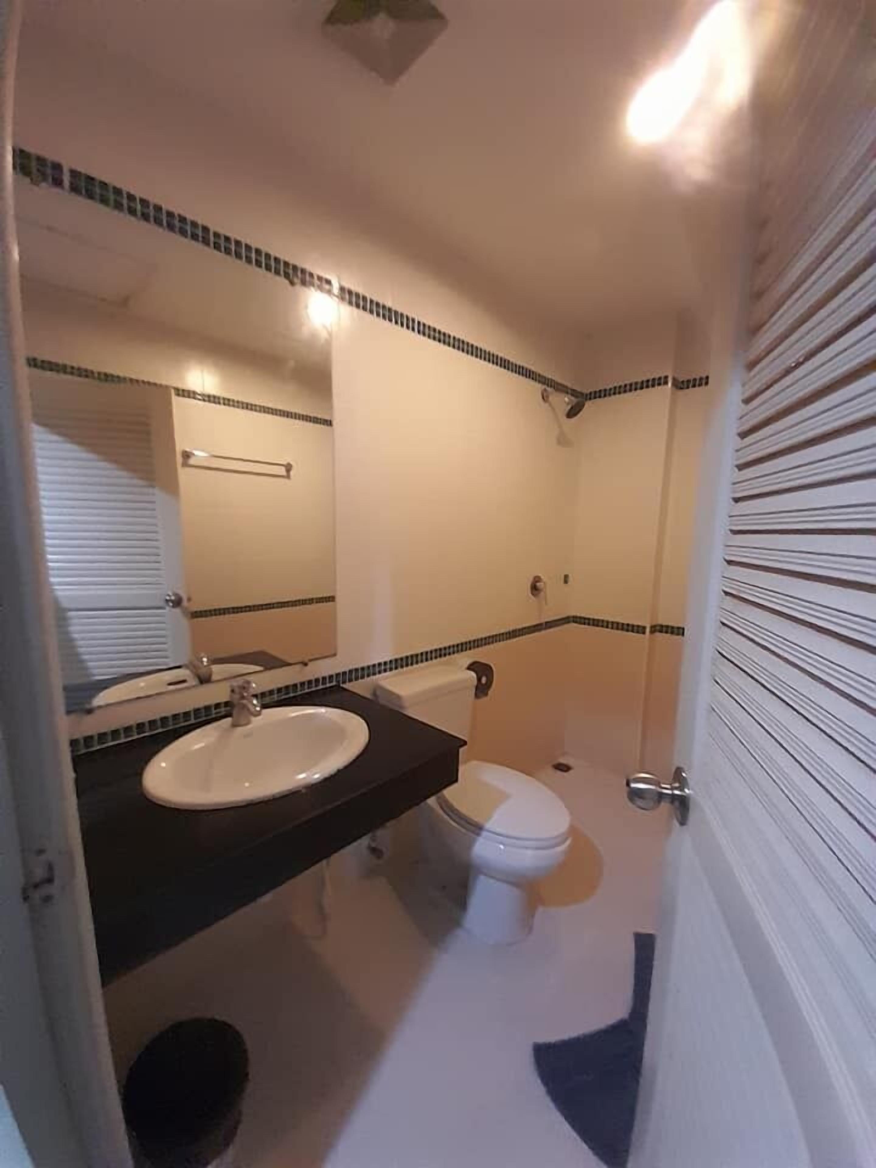 A bathroom with a sink, toilet, and shower.