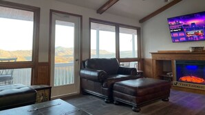 Ein Wohnzimmer mit einer Ledersofa, einem Kamin und einem Fernseher.