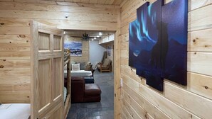 Ein heller Innenbereich mit Holzboden, einem Bett, einer Couch und Bildern an den Wänden.