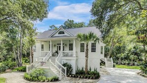 A two-story house with a front porch, a staircase, and a well-maintained garden. - Award-Winning Resort Amenities | Fairway Oaks 33 (Isle of Palms)