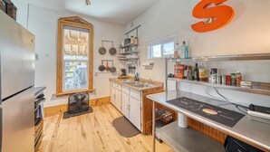 A modern kitchen with wooden flooring, a large window, and a fan. - The Brick Unit B on F st Downtown Salida! (Salida)
