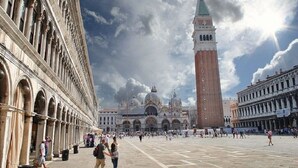 A spacious square with historic buildings, a prominent tower, and a large dome structure.