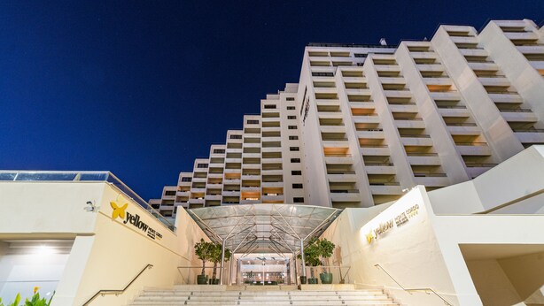 A hotel entrance with a modern design, featuring a glass canopy over the stairs and a sign for 'Yellow House Hotel'. - Yellow Praia Monte Gordo (Vila Real Santo Antonio)