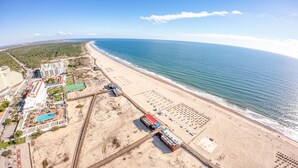 An aerial view of a coastal resort with a beach, a swimming pool, and a tennis court. - Yellow Praia Monte Gordo (Vila Real Santo Antonio)