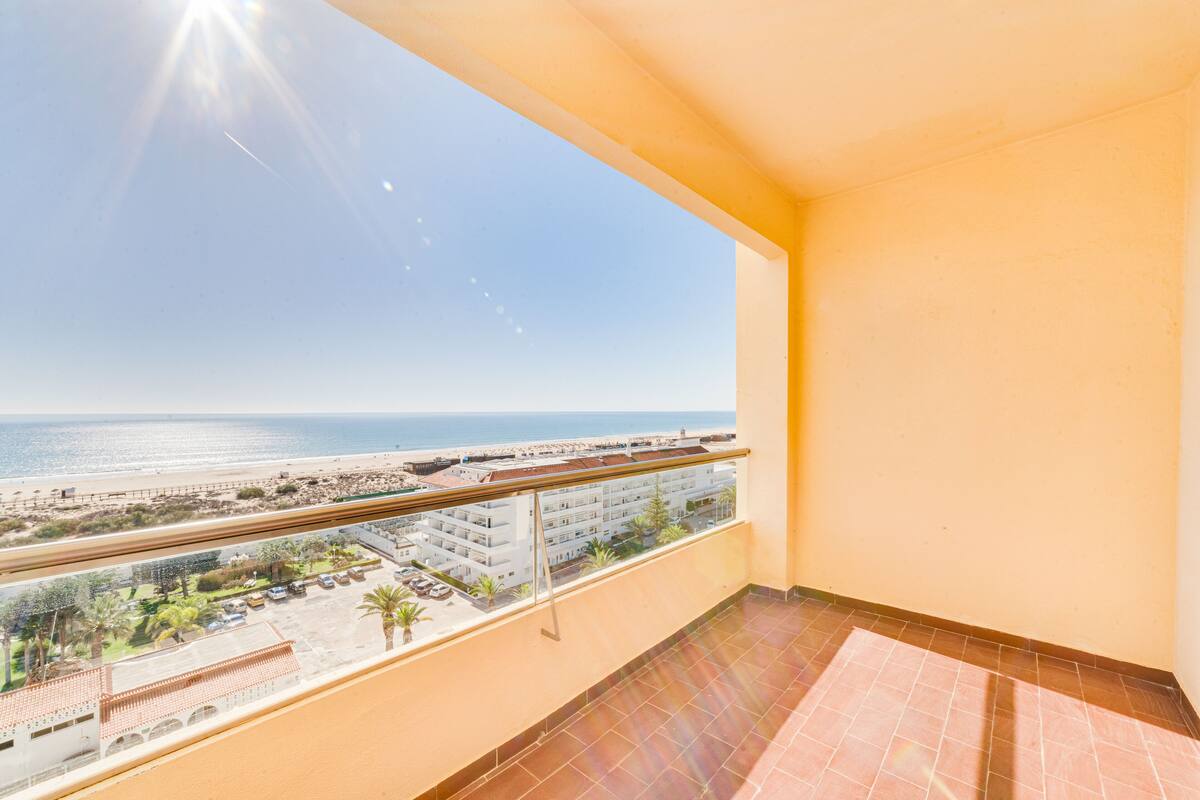 Un balcón con vista a la playa y al océano.