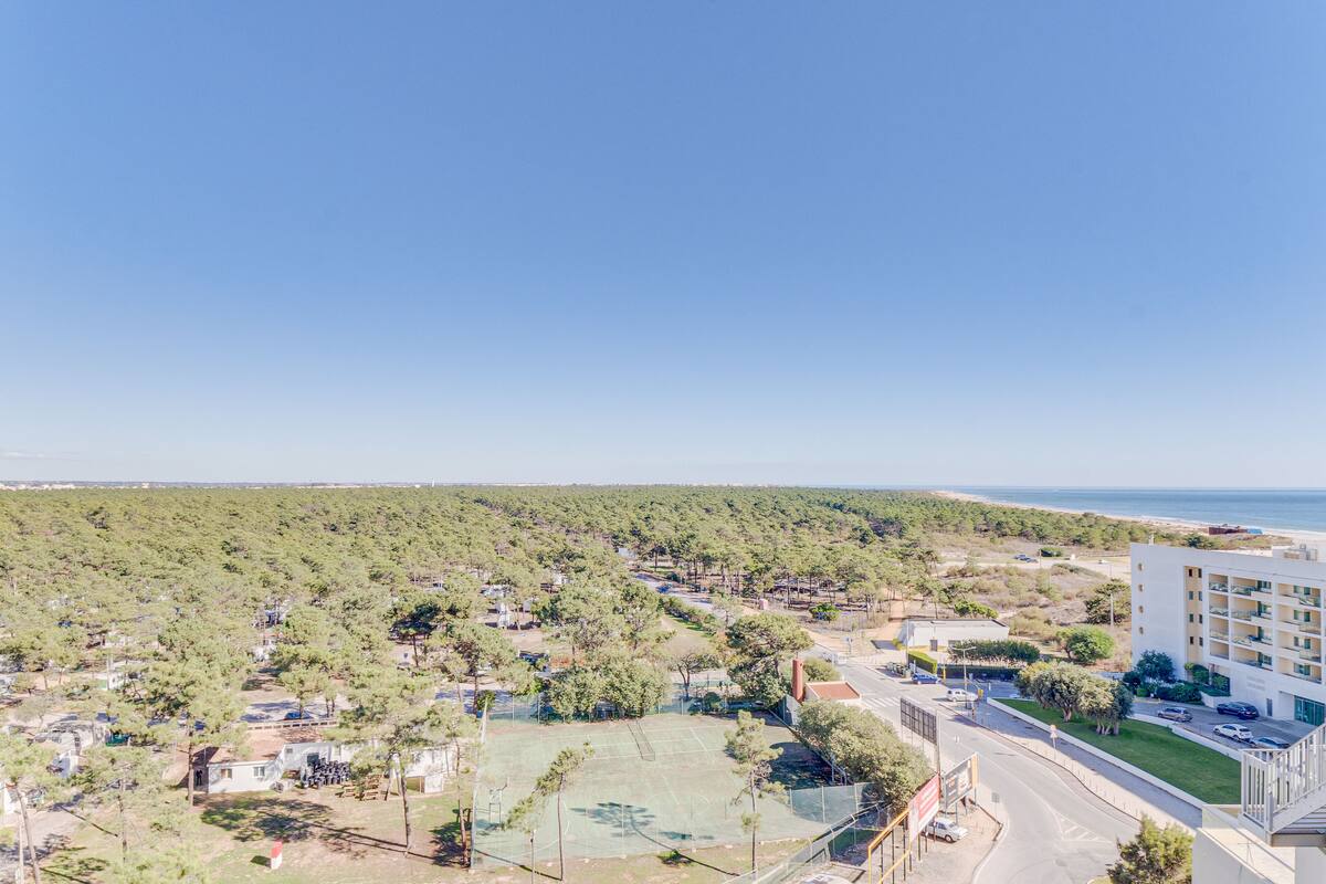 Zona residencial con cancha de tenis, una calle y un edificio con balcones.