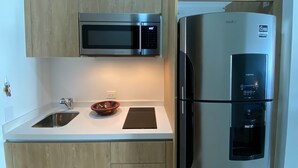 Eine moderne Küche mit einem Edelstahlkühlschrank, einer integrierten Mikrowelle und einem Wasserspender.