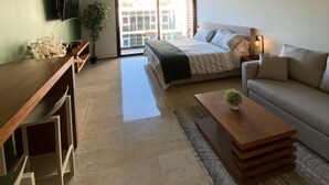 Ein modernes Wohnzimmer mit Bett, Sofa und Couchtisch.