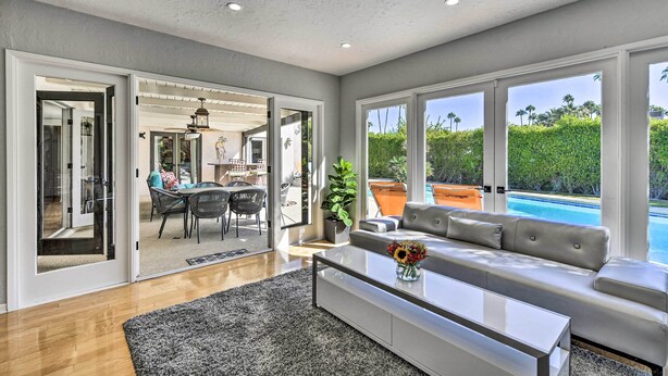 Un salon moderne avec un canapé, une table basse et une vue sur une piscine.