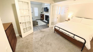 A bedroom with a bed, a dresser, and a closet with sliding doors.