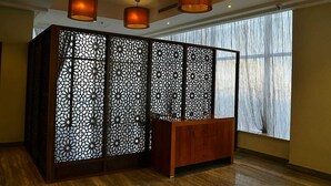 A room with a wooden cabinet, decorative screens, and hanging lamps. - Wonder Palace Hotel Qatar (Doha)
