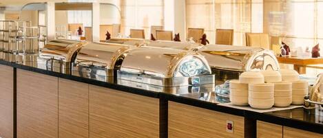 A buffet setup with multiple food stations, including a coffee machine and various serving dishes.