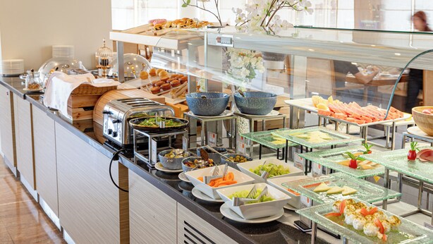 A buffet with various food items and a glass display case. - Wonder Palace Hotel Qatar (Doha)