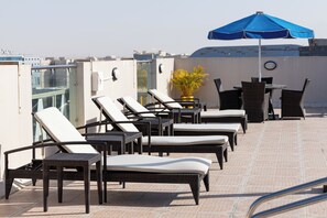 Una piscina al aire libre, tumbonas