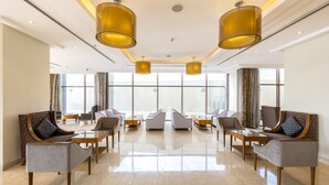 A spacious lobby with modern furniture, large windows, and a clean, polished floor. - Wonder Palace Hotel Qatar (Doha)