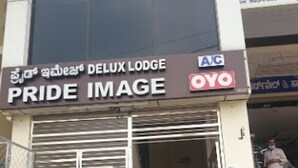 En hotellentrén med en skylt som visar texten ”PRIDE IMAGE” och ”DELUX LODGE”.