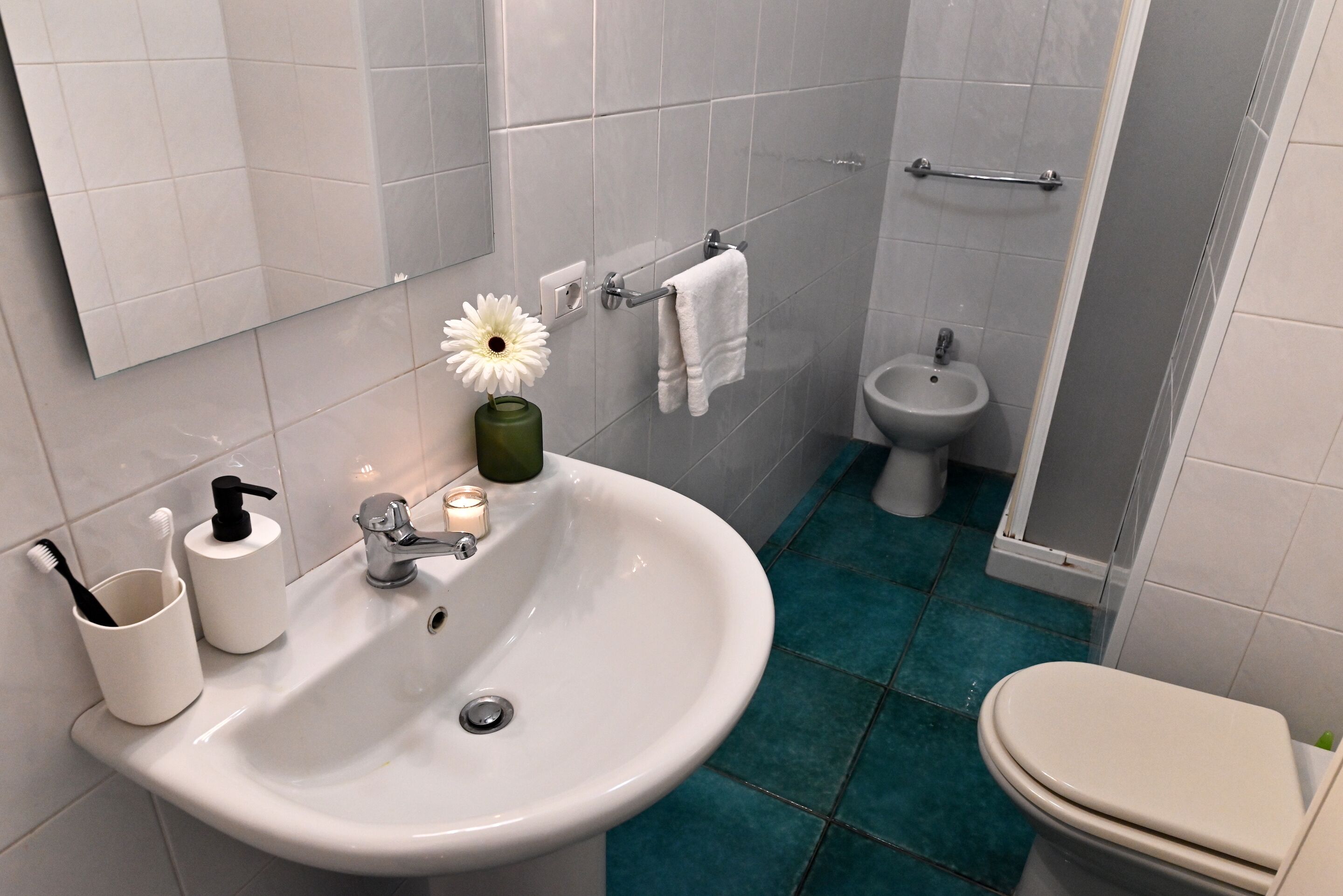 A bathroom with a white sink, a bidet, and a toilet.