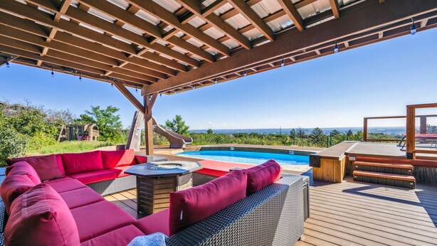 Un espacio al aire libre cubierto con piscina, tobogán y asientos.