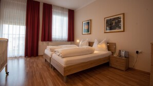 Una camera da letto ordinata con un letto in legno, due comodini e un tavolino da notte.