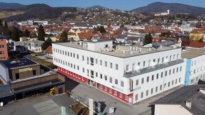 Un edificio a più piani con tetto piatto, ampie finestre e un cartello ben visibile con la scritta "MEDZENTRUM".