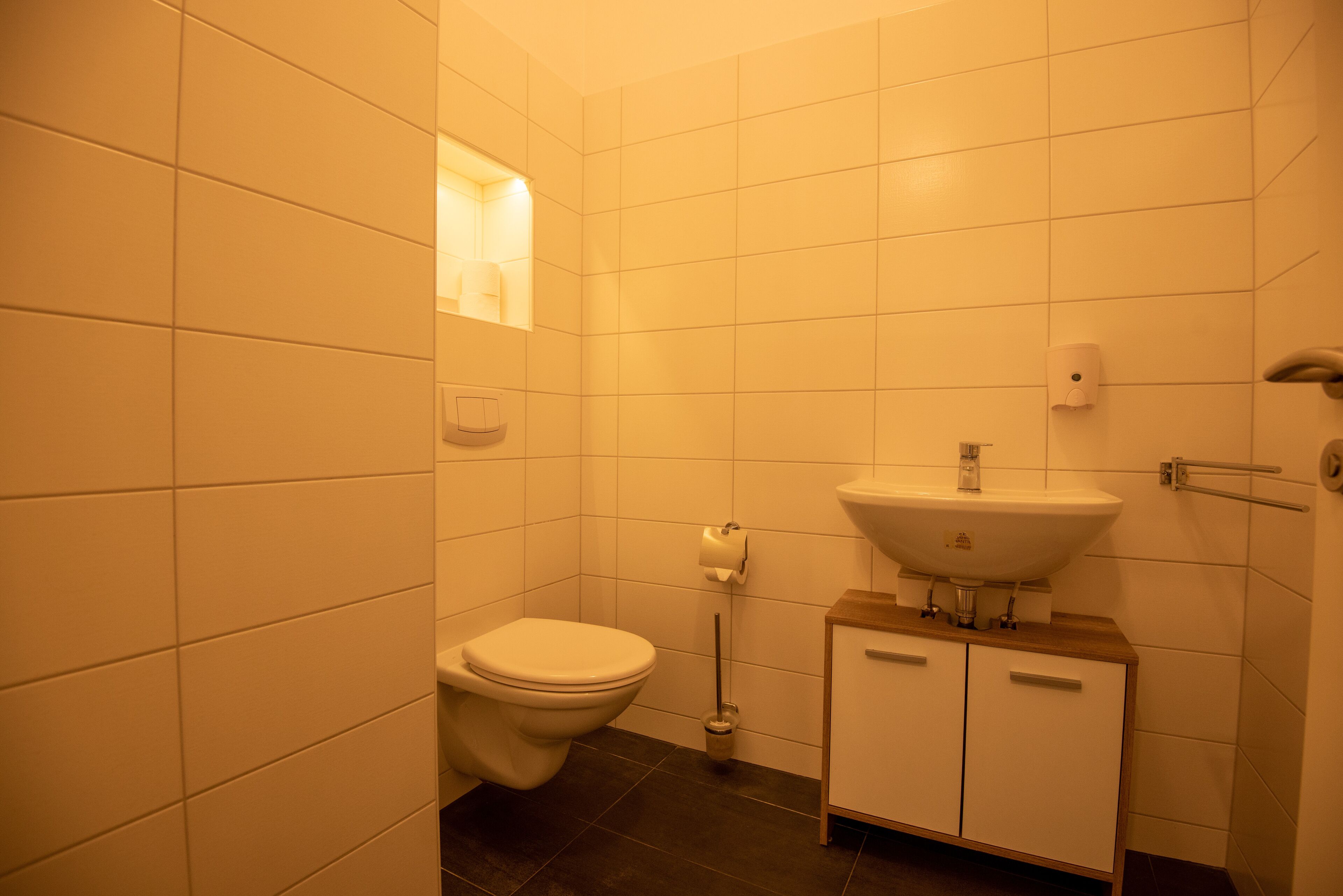 A small bathroom with a toilet, sink, and a mirror.