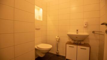 A small bathroom with a toilet, sink, and a mirror.