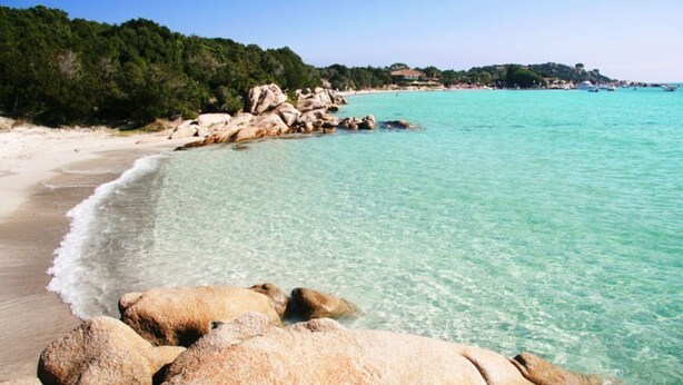 A coastal beach with clear turquoise water, large rocks, and a forested hillside. - 3-star ANCV-approved house in a lovely condominium (SANTA MARIA POGGIO)